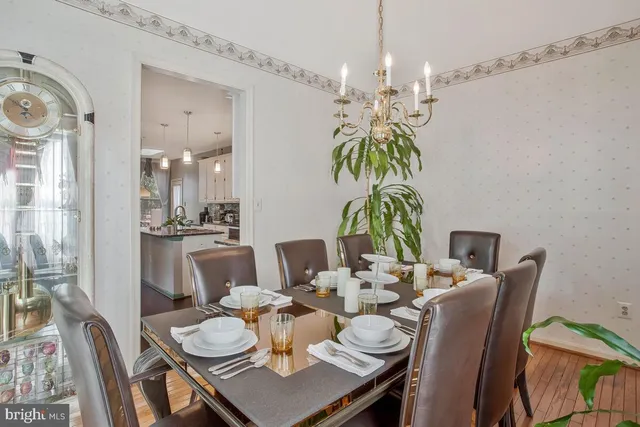 a dining room with furniture a chandelier and wooden floor