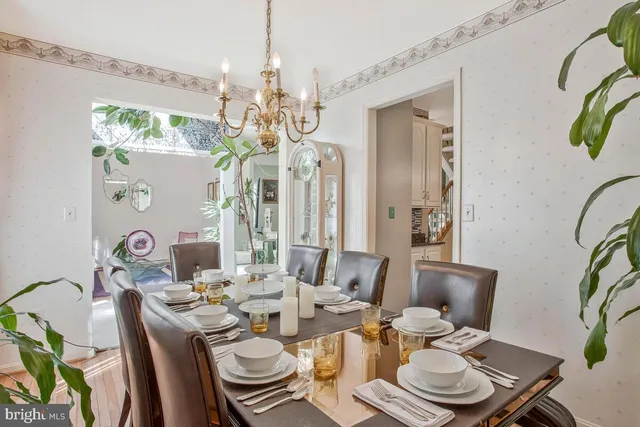 a view of a dining room with furniture a chandelier and wooden floor