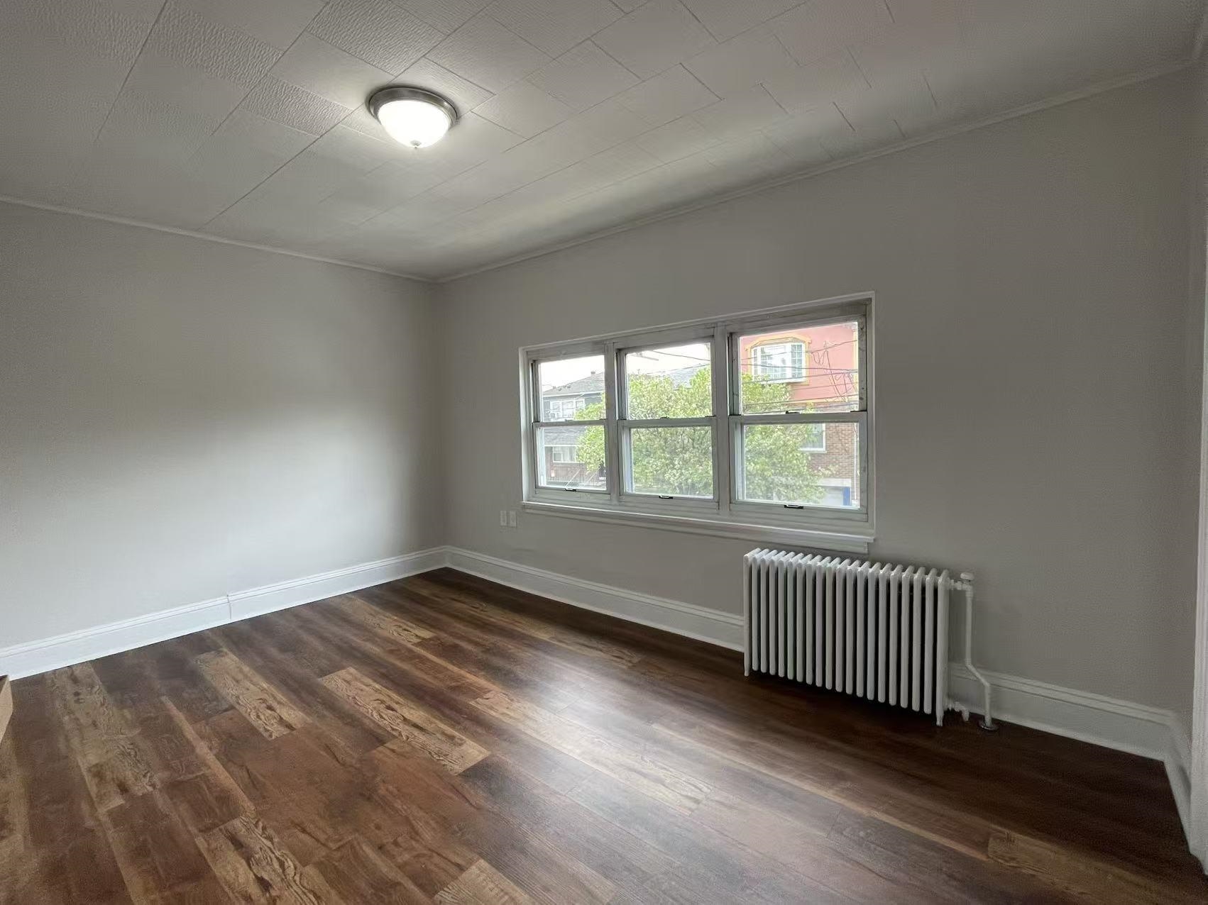 109 70th Street, Unit 2 Guttenberg, NJ 07093 - Photo 12 of 17 an empty room with wooden floor and windows