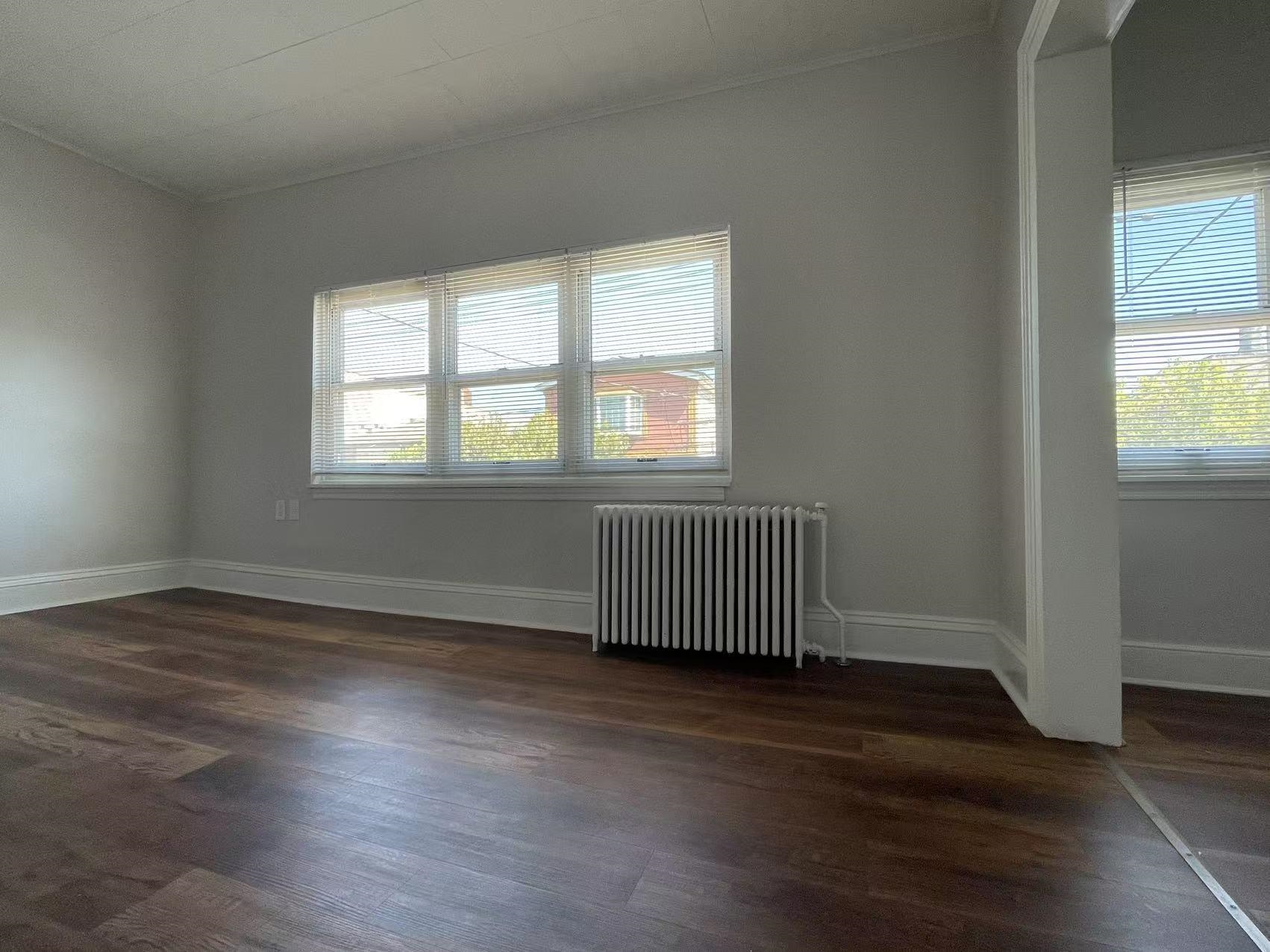 109 70th Street, Unit 2 Guttenberg, NJ 07093 - Photo 13 of 17 an empty room with wooden floor and windows