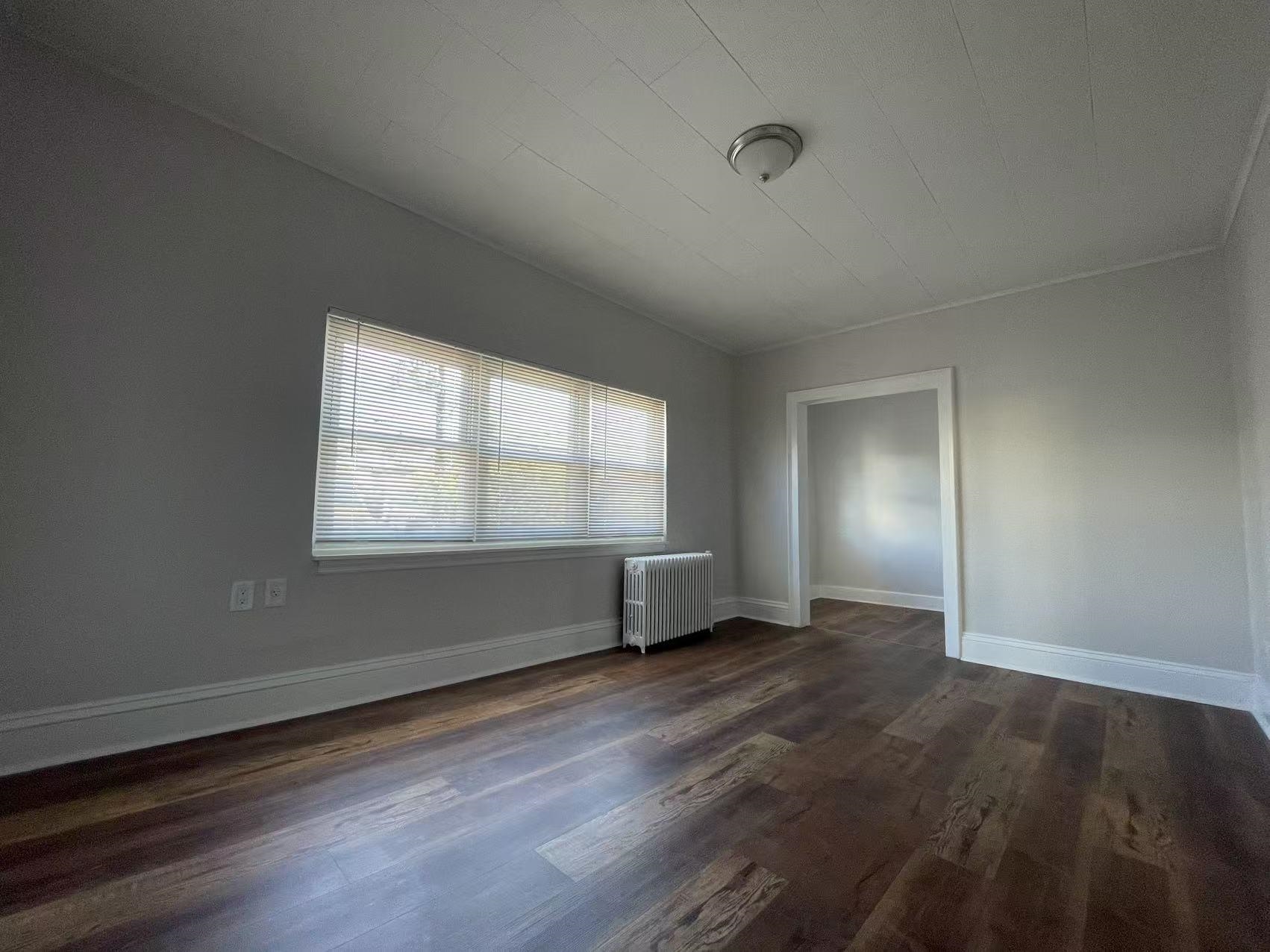 109 70th Street, Unit 2 Guttenberg, NJ 07093 - Photo 14 of 17 an empty room with wooden floor and windows