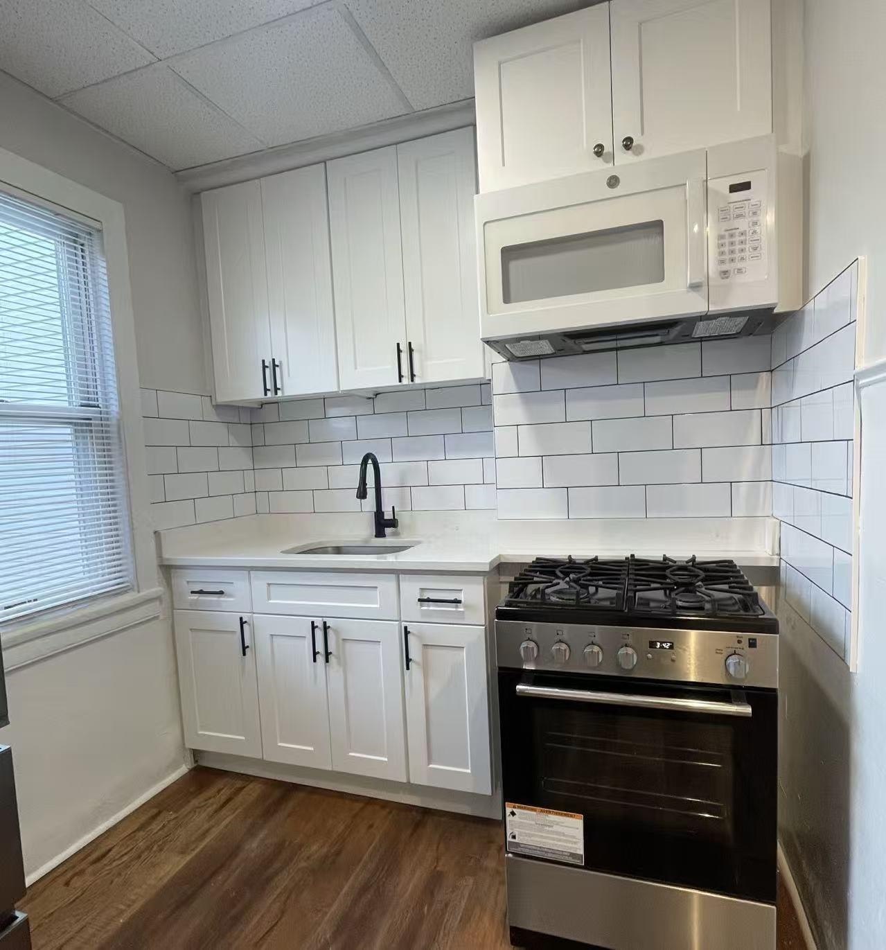 109 70th Street, Unit 2 Guttenberg, NJ 07093 - Photo 15 of 17 a kitchen with cabinets stainless steel appliances and wooden floor