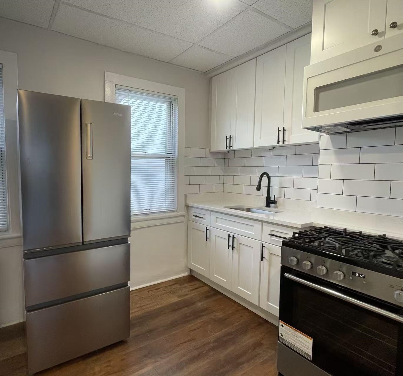 109 70th Street, Unit 2 Guttenberg, NJ 07093 - Photo 16 of 17 a kitchen with a refrigerator stove and wooden cabinets