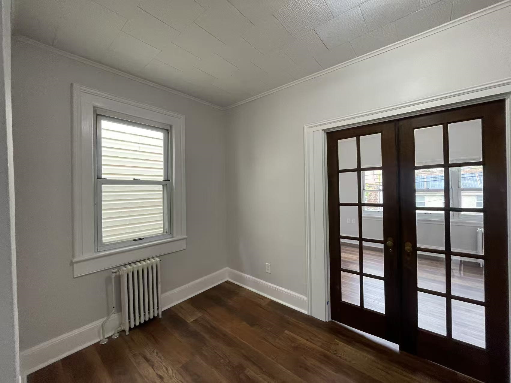 109 70th Street, Unit 2 Guttenberg, NJ 07093 - Photo 3 of 17 a view of an empty room with wooden floor and a window