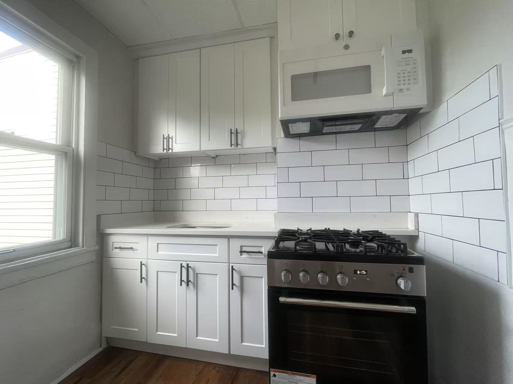 109 70th Street, Unit 2 Guttenberg, NJ 07093 - Photo 4 of 17 a kitchen with stainless steel appliances a stove a sink dishwasher and cabinets