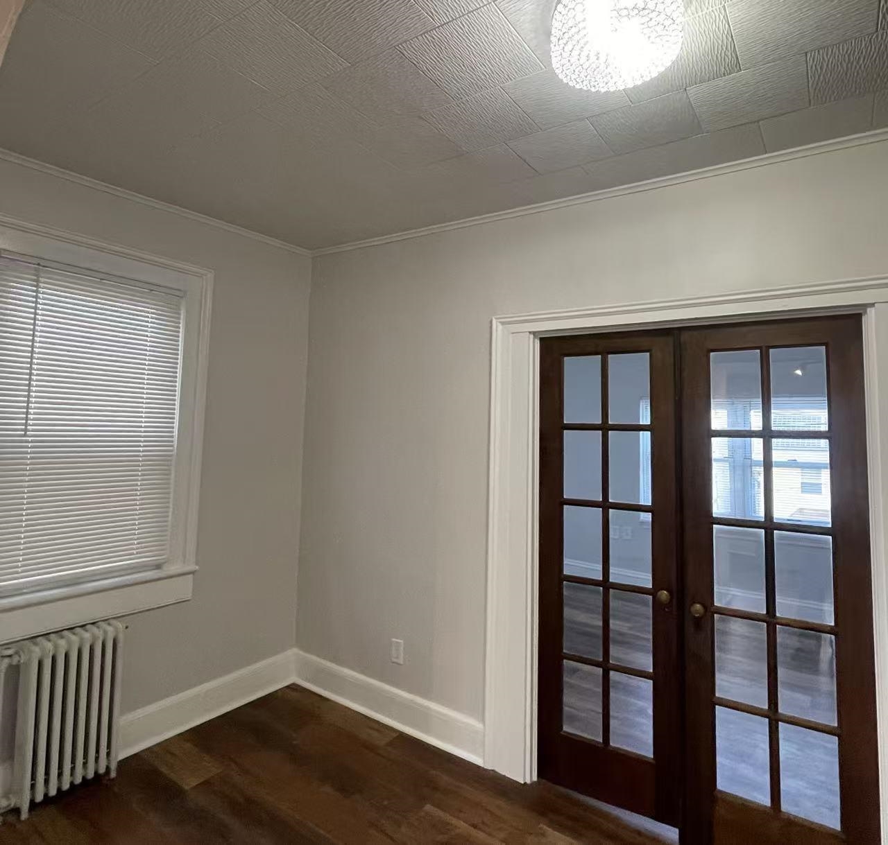 109 70th Street, Unit 2 Guttenberg, NJ 07093 - Photo 9 of 17 a view of an empty room with wooden floor and a window