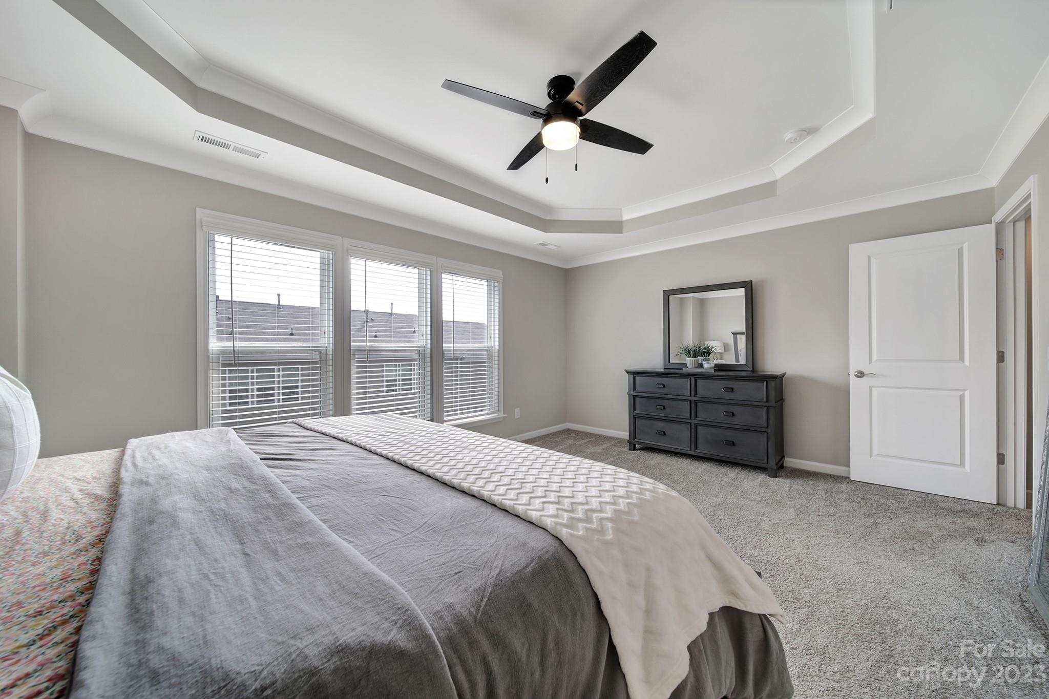 816 Canoe Song Road Fort Mill, SC 29708 - Photo 12 of 24 a spacious bedroom with a bed a dresser and a large window