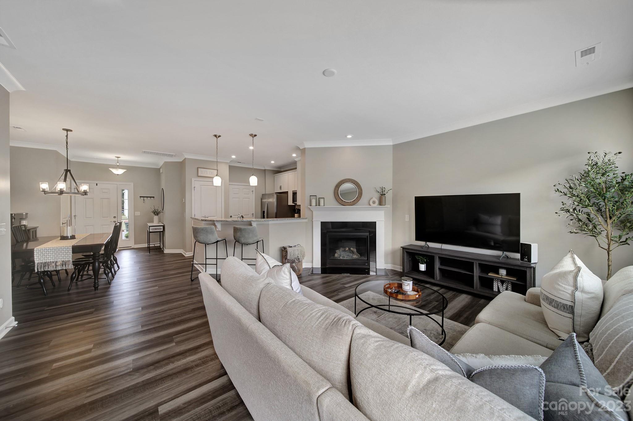 816 Canoe Song Road Fort Mill, SC 29708 - Photo 9 of 24 a living room with furniture a fireplace a flat screen tv and a dining table