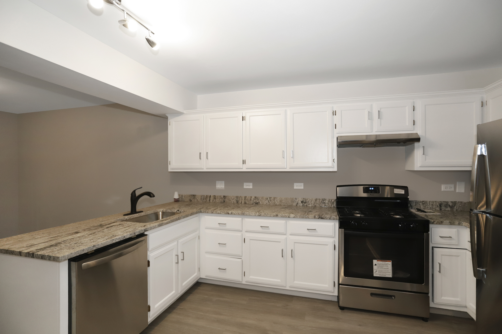 100 Ravinia Drive Shorewood, IL 60404 - Photo 14 of 33 a kitchen with granite countertop white cabinets and black appliances