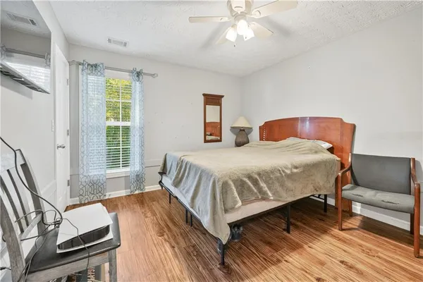 a bedroom with a bed and wooden floor