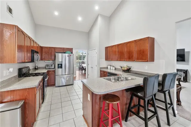 a kitchen with stainless steel appliances granite countertop a sink counter space and a refrigerator