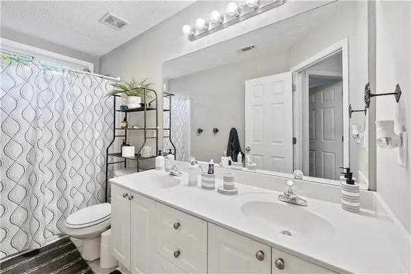 a bathroom with a double vanity sink mirror and toilet