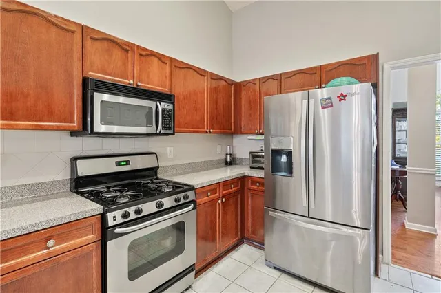 a kitchen with granite countertop a refrigerator stove and microwave