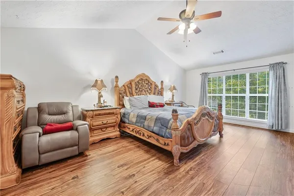 a bedroom with a bed and wooden floor