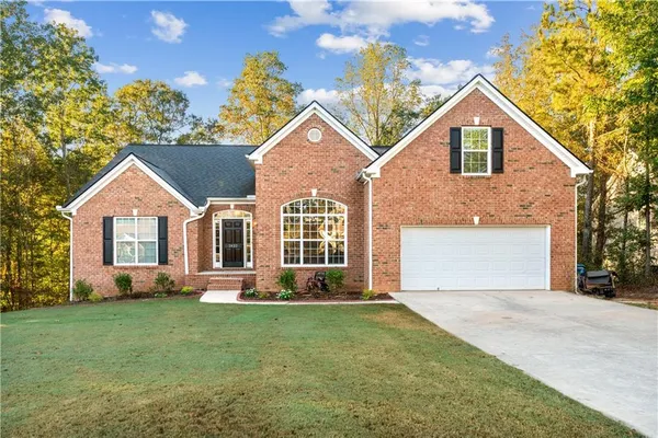 a front view of a house with a yard and trees