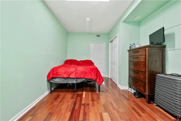 a view of a bedroom with wooden floor and furniture