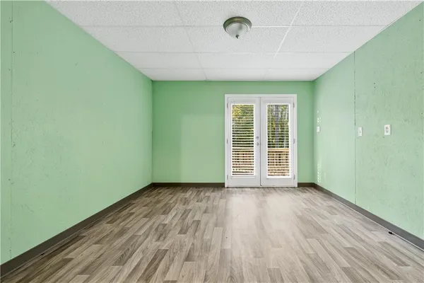 an empty room with wooden floor and windows