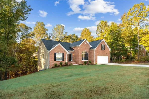 a front view of a house with a yard and trees