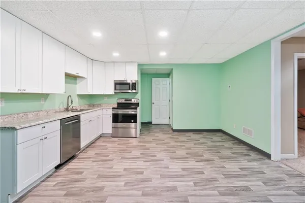 a large kitchen with stainless steel appliances granite countertop a stove a sink and a refrigerator