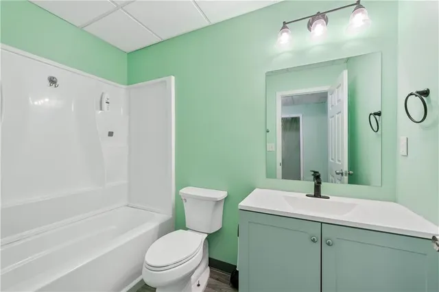 a bathroom with a sink a toilet and a large mirror