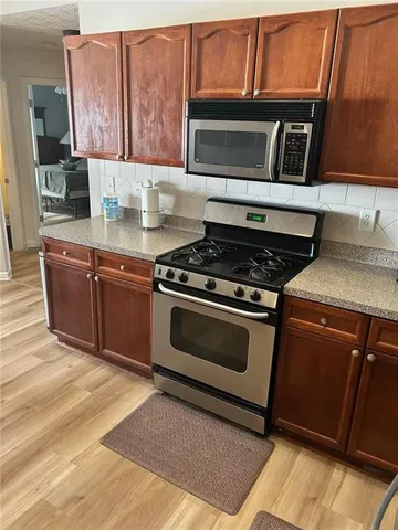 a kitchen with granite countertop a stove top oven cabinetry a sink and a counter