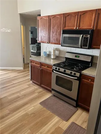 a kitchen with wooden cabinets and stainless steel appliances