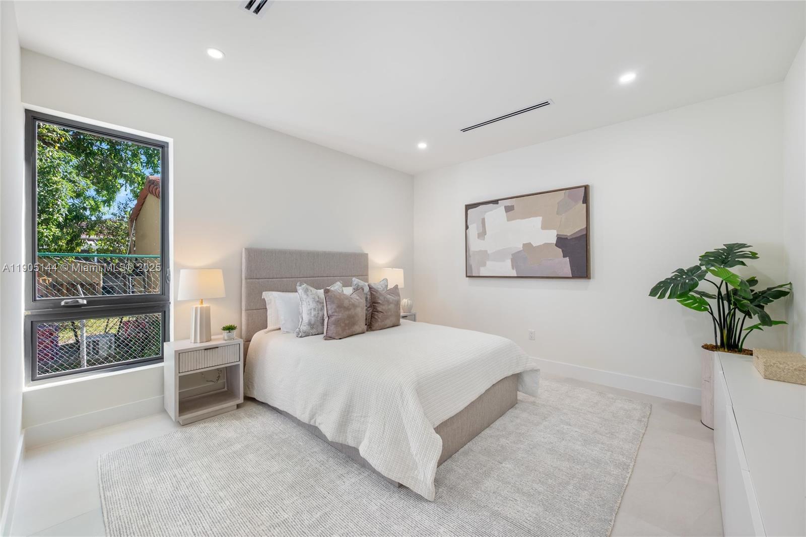 2127 Southwest 11th Terrace Miami, FL 33135 - Photo 16 of 28 a bedroom with a large bed and a potted plant