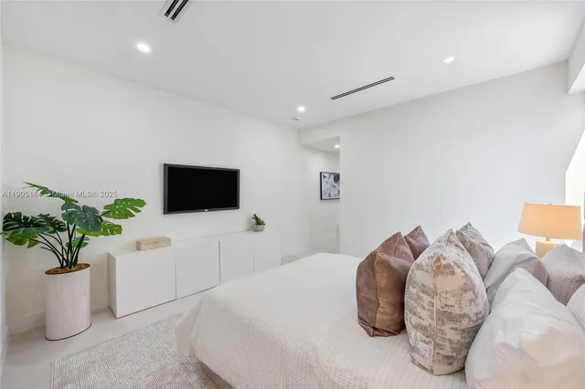 a bedroom with a bed and a potted plant