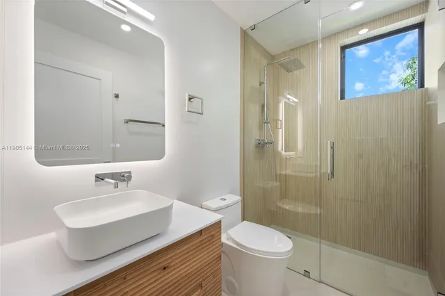 a bathroom with a sink a toilet and shower