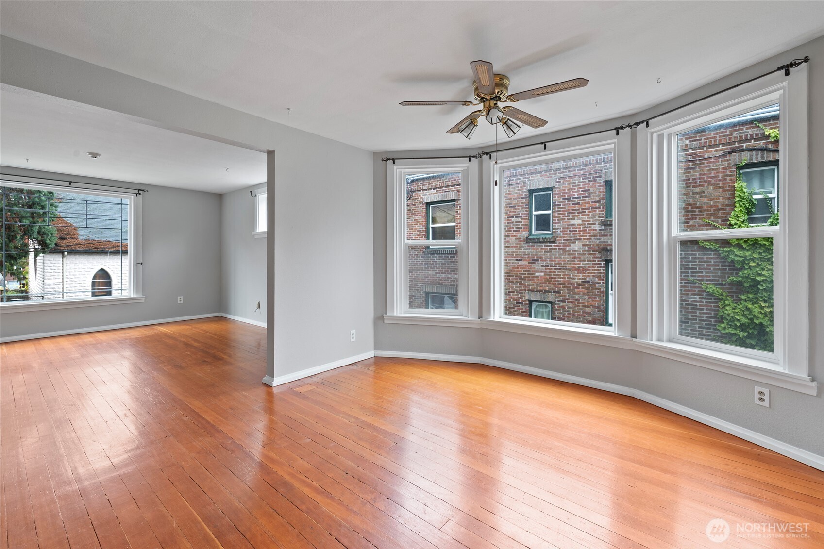 908 South 5th Street Tacoma, WA 98405 - Photo 3 of 6 a view of an empty room with wooden floor and a window