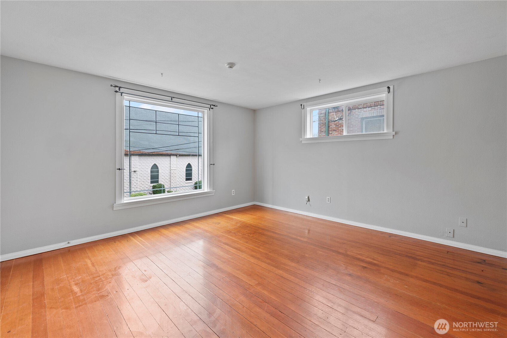 908 South 5th Street Tacoma, WA 98405 - Photo 4 of 6 a view of an empty room with wooden floor and a window