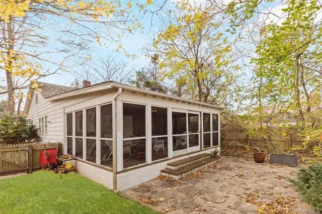 a view of a house with a yard and large tree