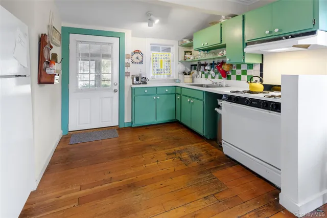 a kitchen with a sink cabinets and wooden floor