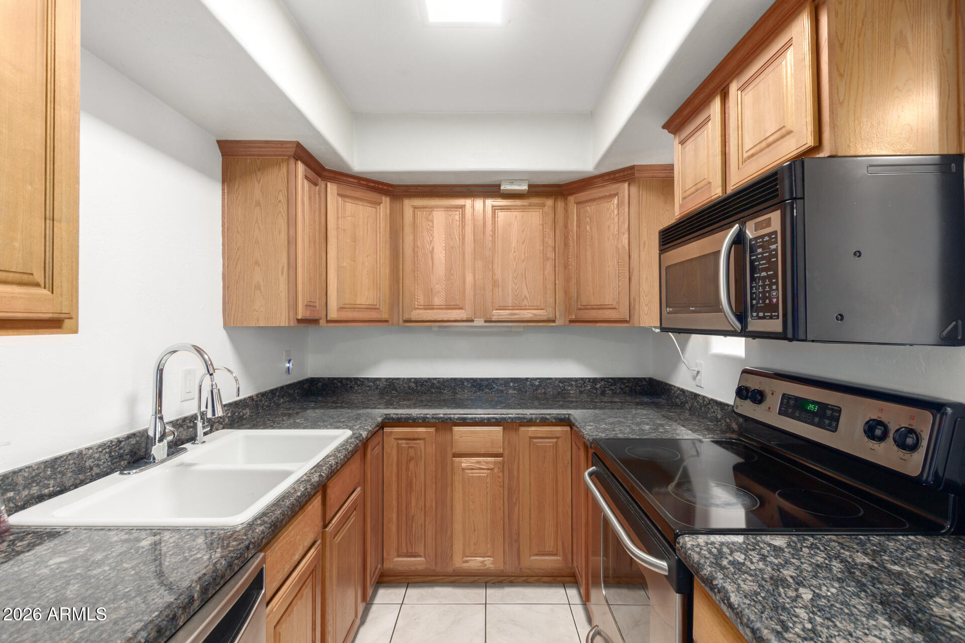 151 East Broadway Road, Unit 103 Tempe, AZ 85282 - Photo 12 of 33 a kitchen with granite countertop a sink a stove and cabinets