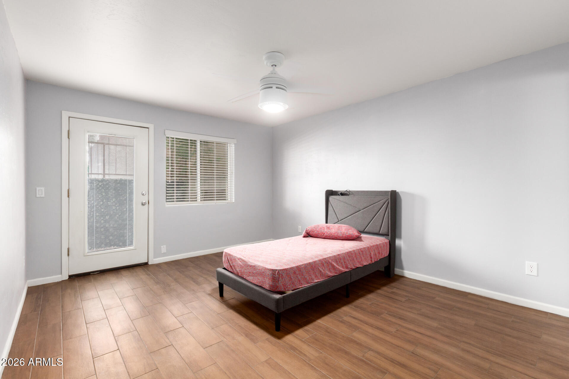 151 East Broadway Road, Unit 103 Tempe, AZ 85282 - Photo 16 of 33 a bedroom with a bed and wooden floor