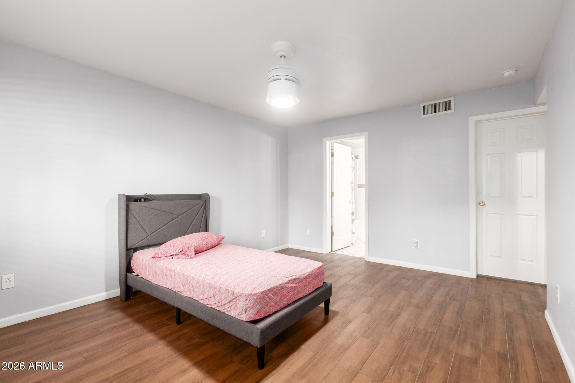 151 East Broadway Road, Unit 103 Tempe, AZ 85282 - Photo 17 of 33 a bedroom with a bed and wooden floor