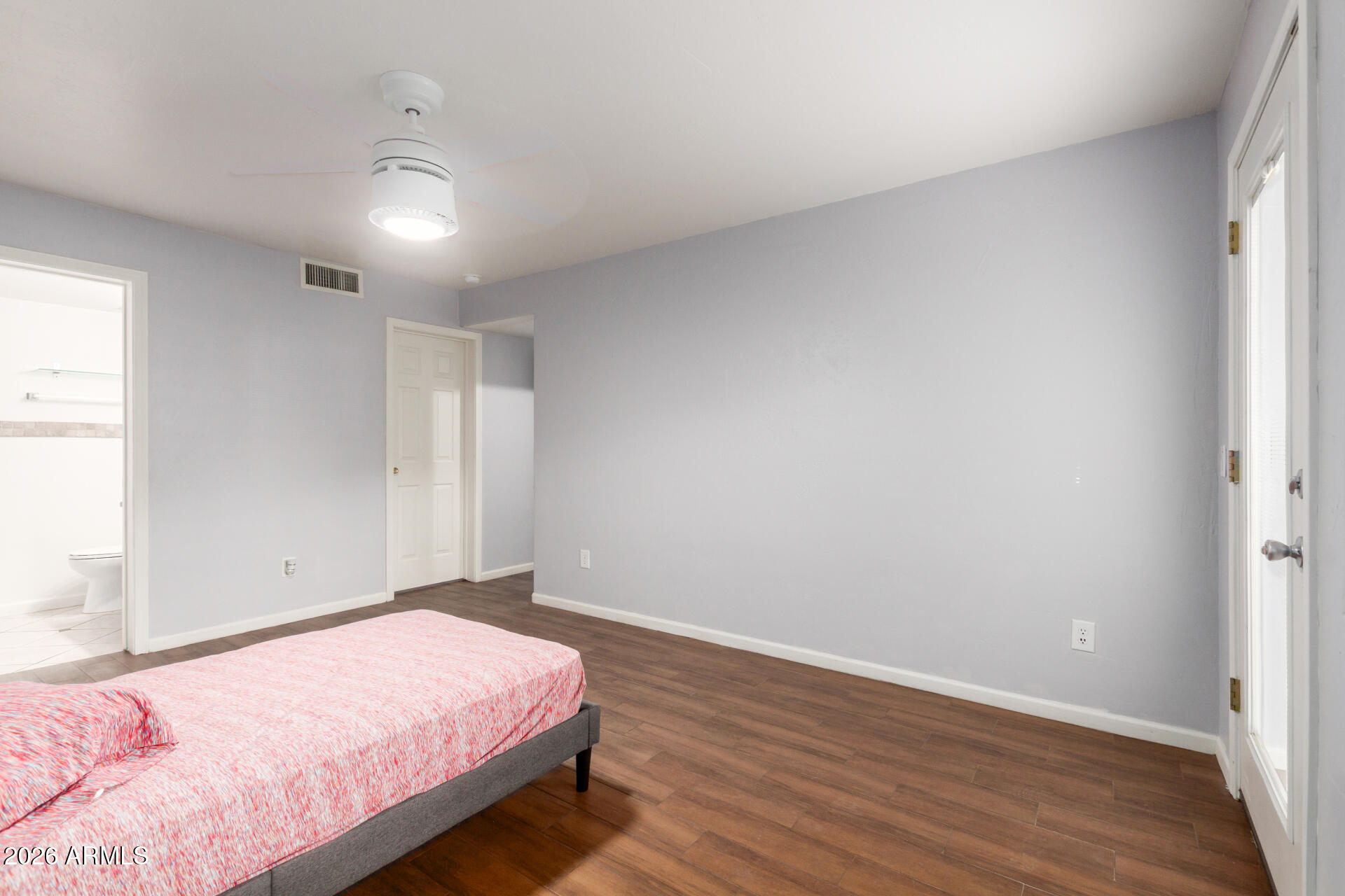 151 East Broadway Road, Unit 103 Tempe, AZ 85282 - Photo 18 of 33 a bedroom with a bed and wooden floor