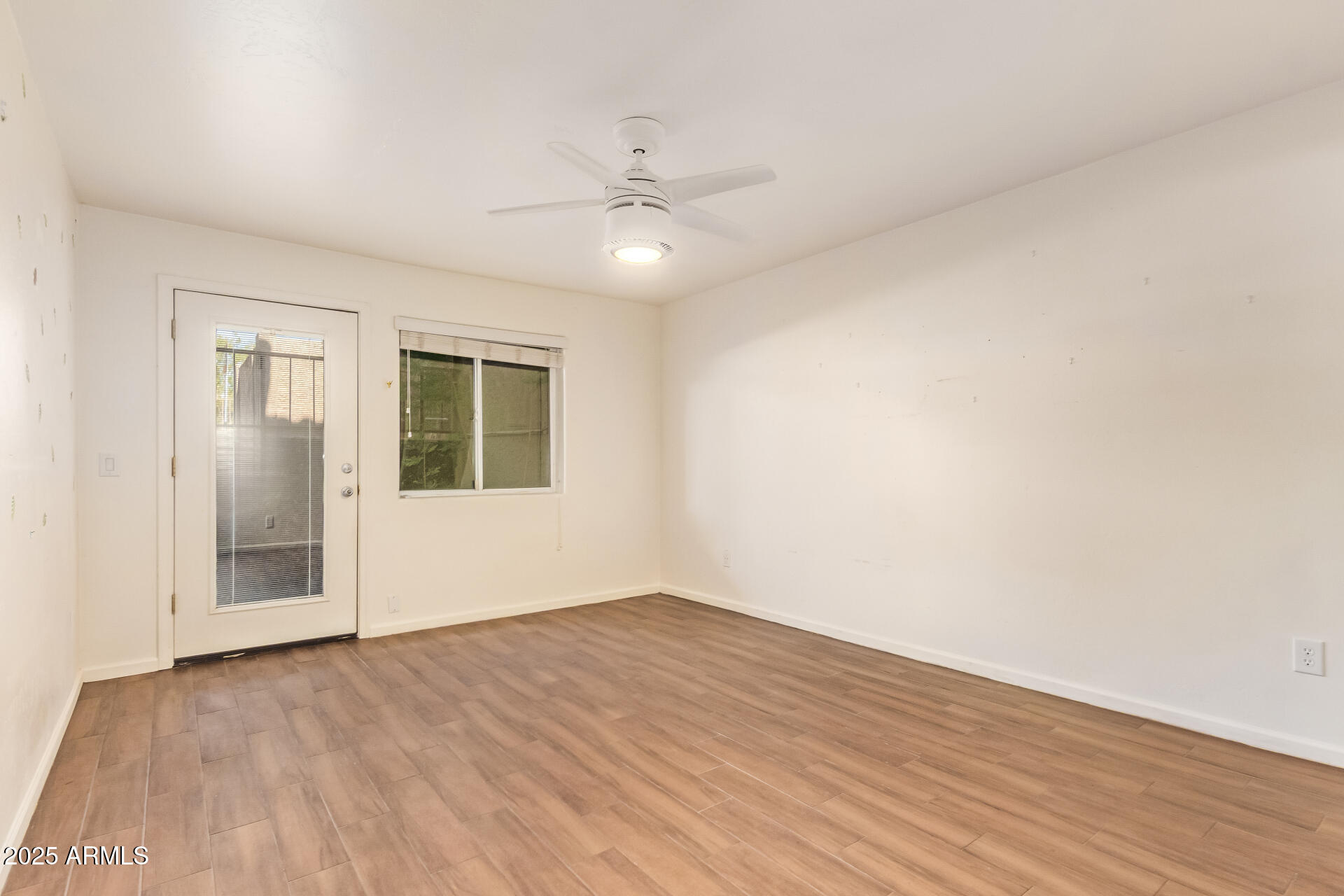 151 East Broadway Road, Unit 103 Tempe, AZ 85282 - Photo 18 of 27 a view of an empty room with wooden floor and a ceiling fan