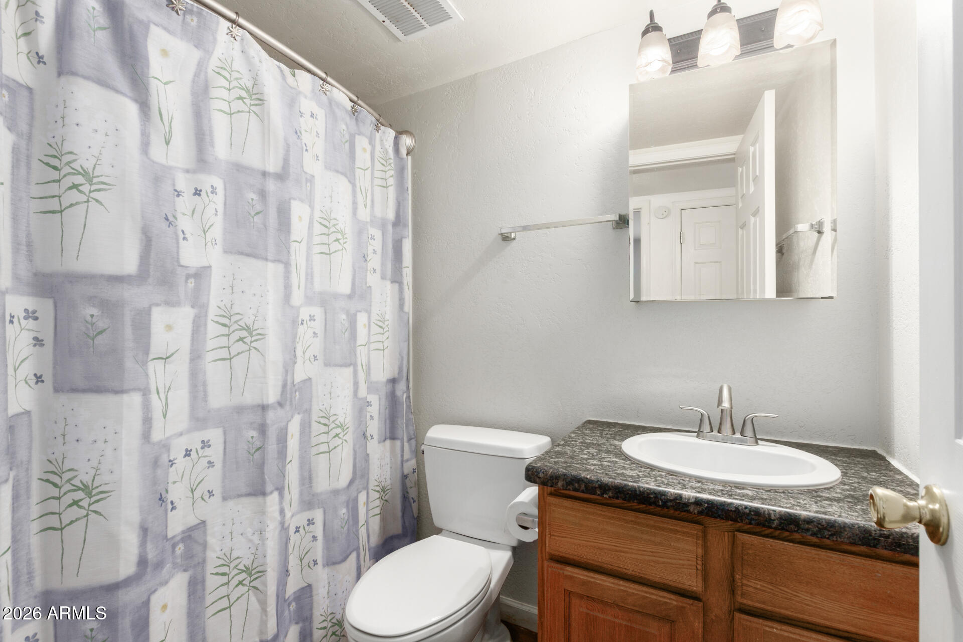 151 East Broadway Road, Unit 103 Tempe, AZ 85282 - Photo 22 of 27 a bathroom with a granite countertop sink a toilet and a mirror