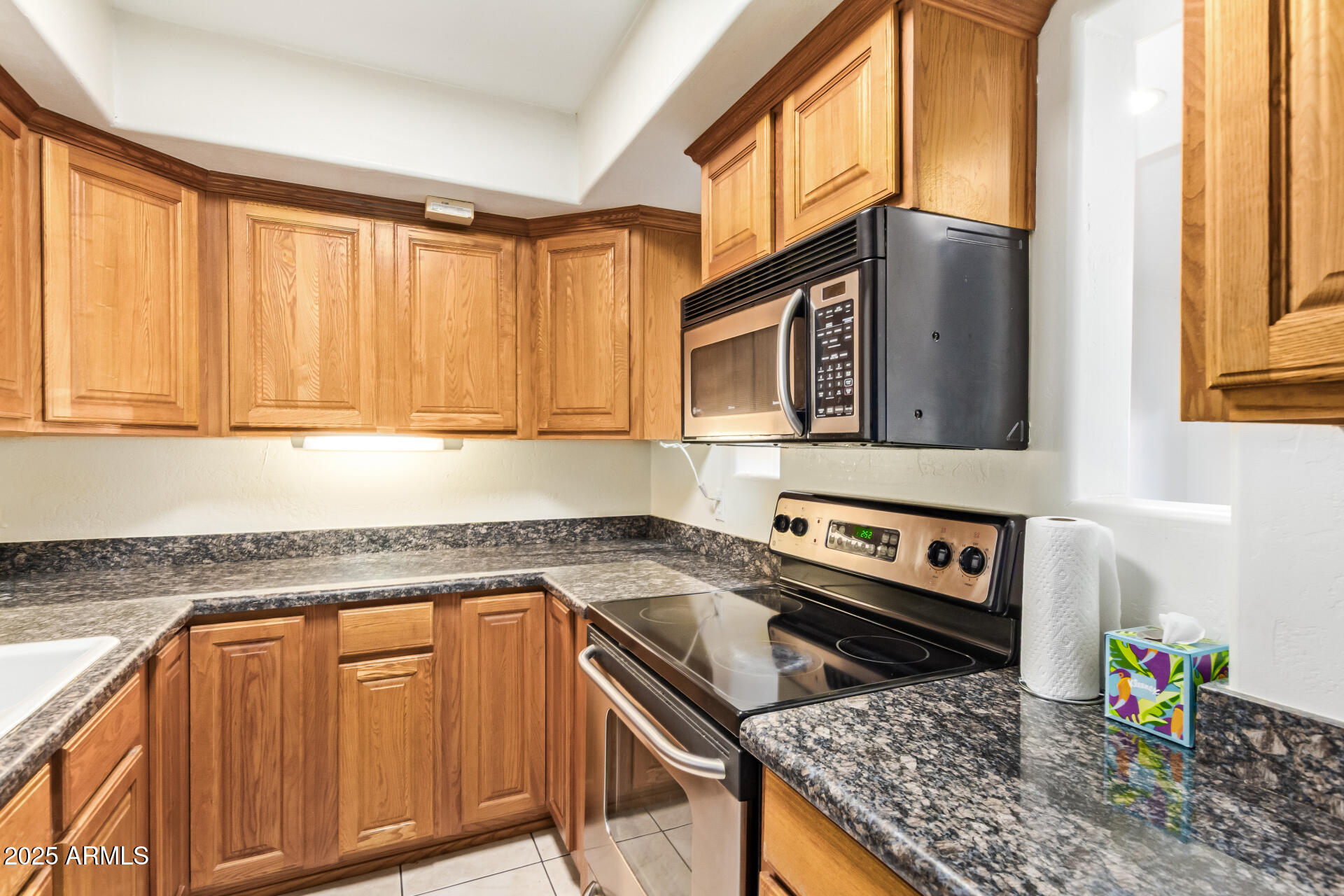 151 East Broadway Road, Unit 103 Tempe, AZ 85282 - Photo 5 of 27 a kitchen with stainless steel appliances granite countertop a stove a sink and a microwave
