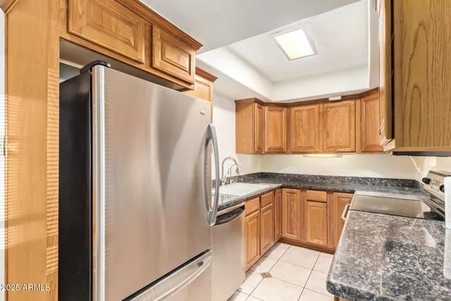 a kitchen with a refrigerator sink and cabinets