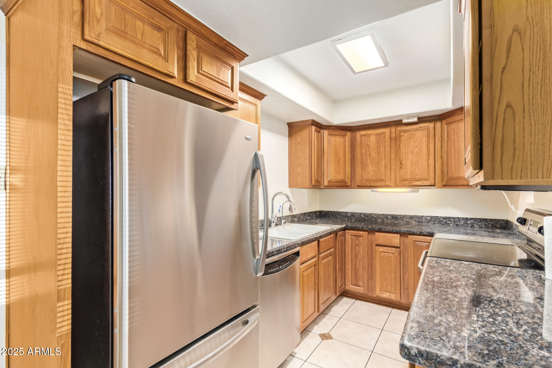 151 East Broadway Road, Unit 103 Tempe, AZ 85282 - Photo 7 of 27 a kitchen with a refrigerator sink and cabinets