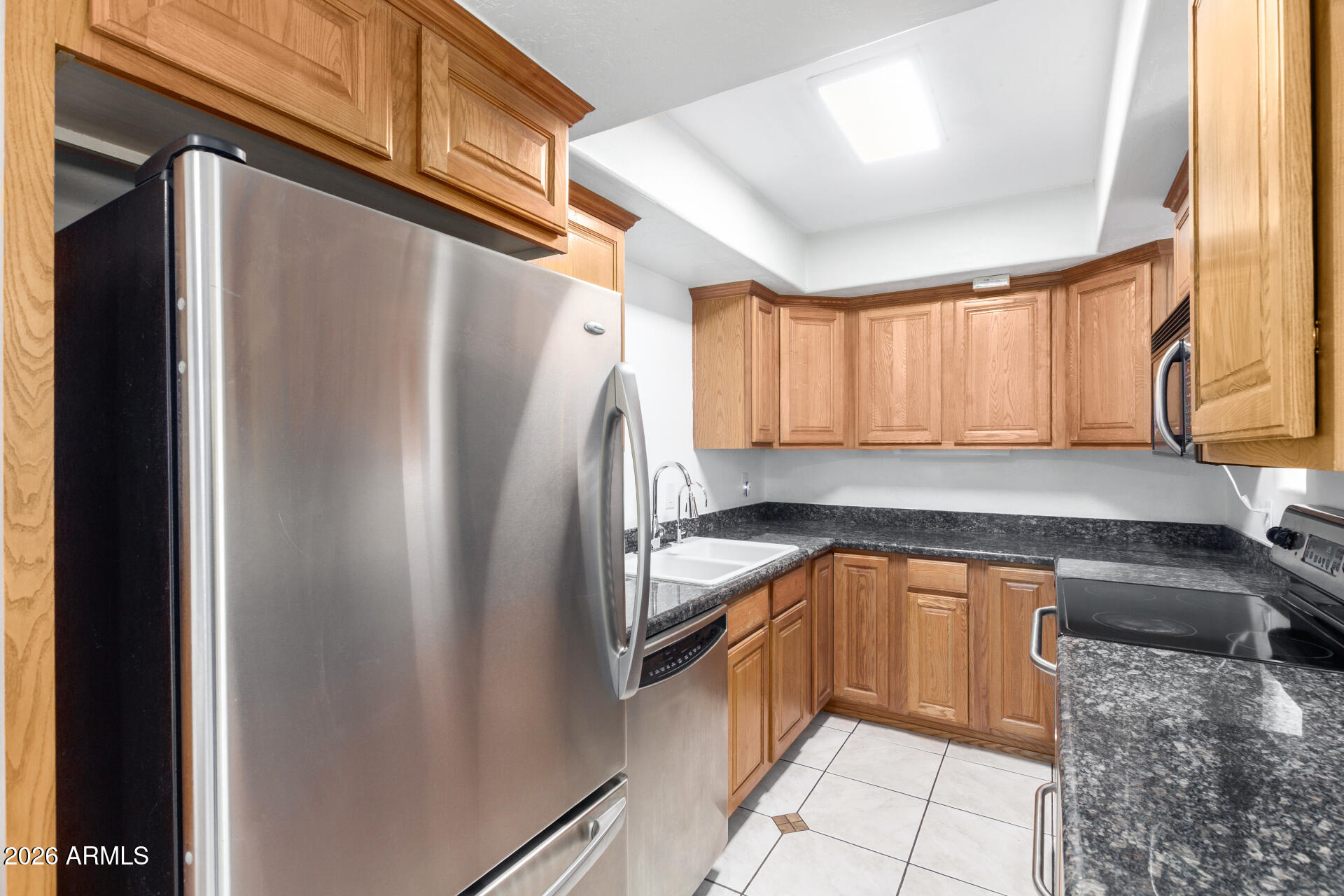 151 East Broadway Road, Unit 103 Tempe, AZ 85282 - Photo 9 of 27 a kitchen with granite countertop a refrigerator and a sink