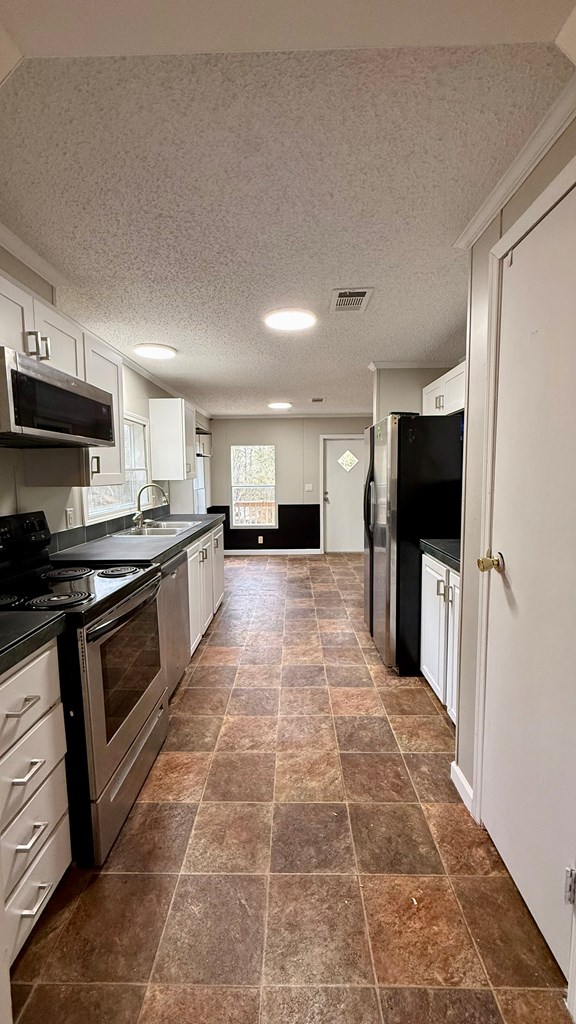 301 Satellite Circle Fortson, GA 31808 - Photo 10 of 24 a kitchen with stainless steel appliances granite countertop a stove a sink and a refrigerator