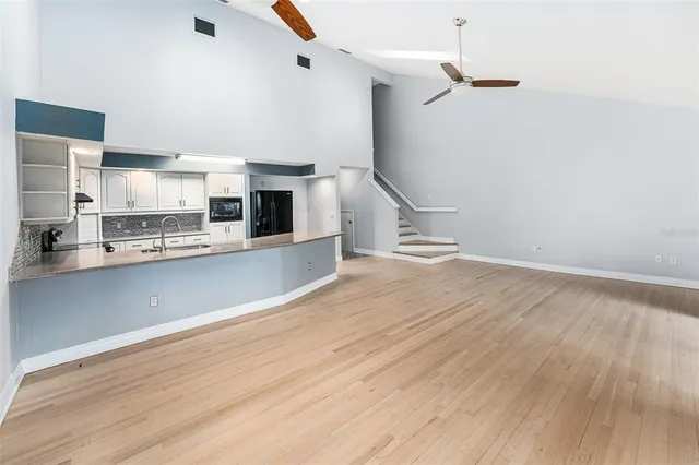a view of a kitchen with white cabinets and wooden floor