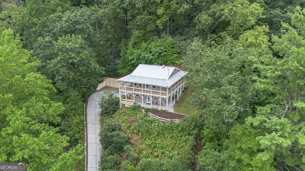 a aerial view of a house with a yard and large trees