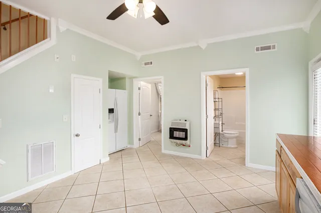 a view of a livingroom with a chandelier fan and windows