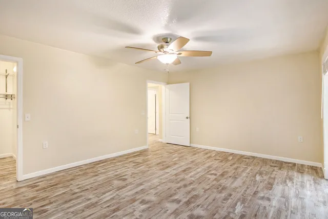 a view of an empty room and chandelier fan