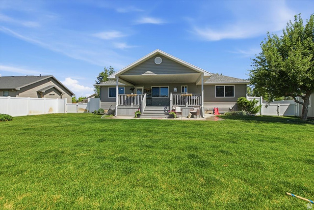 772 East 600 South Preston, ID 83263 - Photo 31 of 35 Expansive backyard with a large, manicured lawn, a covered porch, an open deck, and white privacy fencing