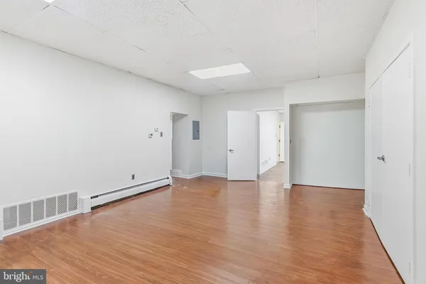 a view of an empty room with wooden floor